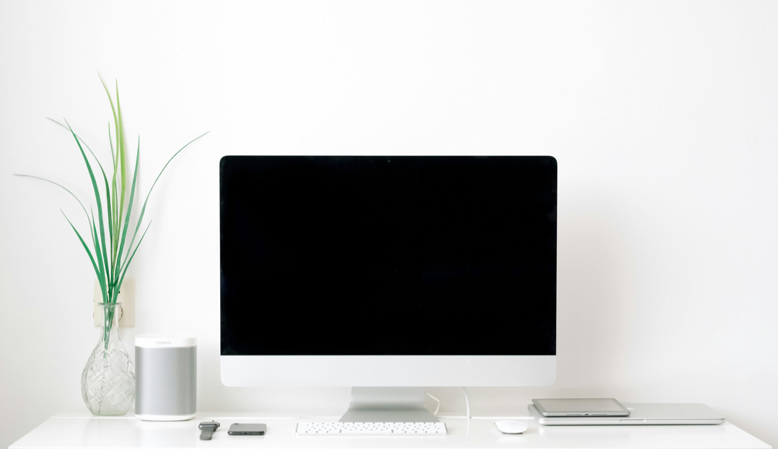 desktop computer in office with plant and speaker